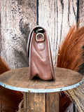 Right side view of brown leather tooled western bag with hardware ring